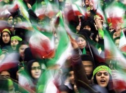 A Téhéran, des étudiants iraniens brandissent le drapeau national lors de la cérémonie d’anniversaire de la Révolution islamique de 1979